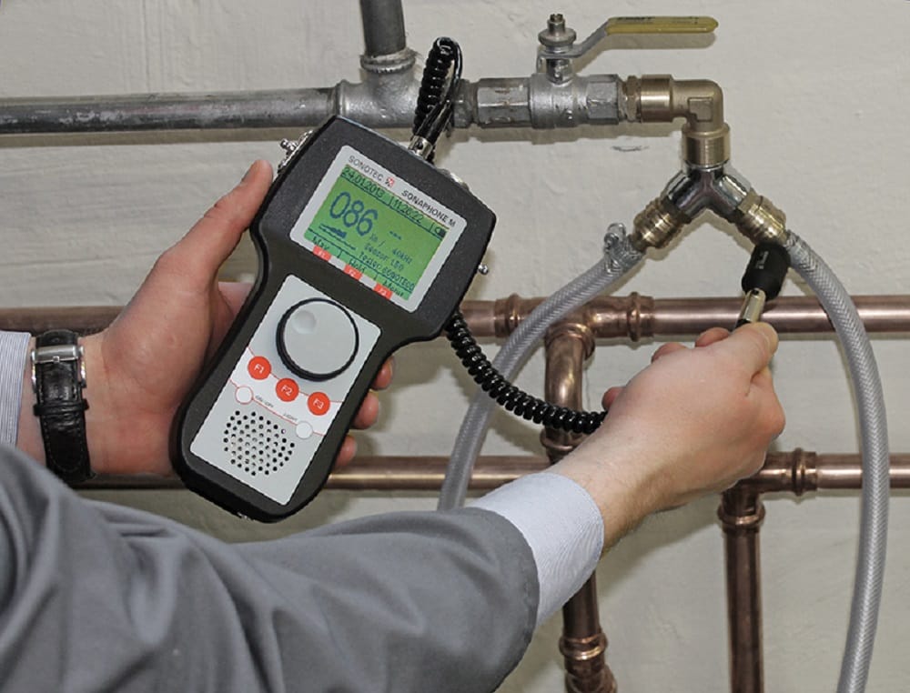 Plumber testing pipes with electronic leak detection equipment in Soledad