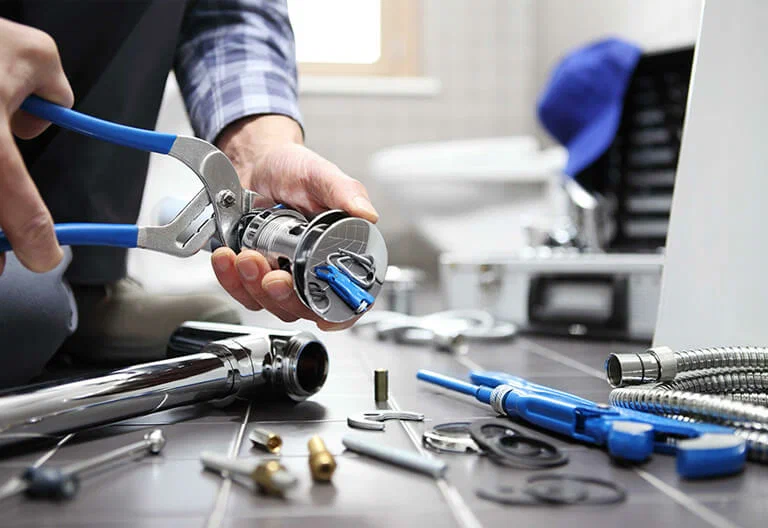 Technician repairing a plumbing fixture with professional tools in Soledad