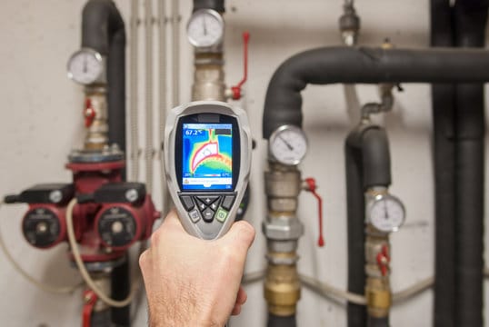 Plumber using a thermal imaging camera to inspect pipes in Soledad