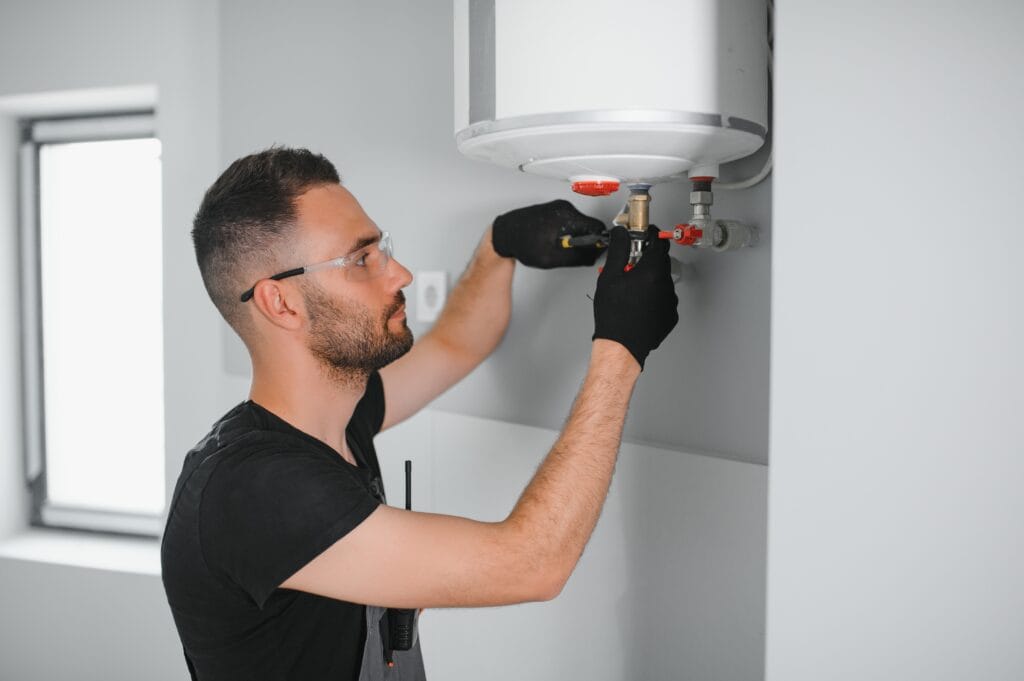 Technician performing water heater maintenance in Soledad