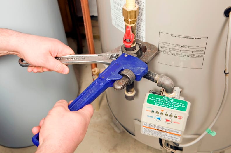 Plumber repairing a water heater valve in Soledad